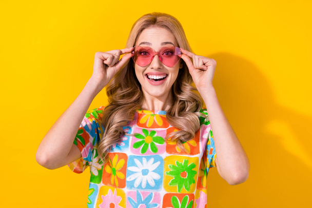 Photo of funny pretty lady try on cool sun glasses see low price shopping promo wear shirt isolated yellow bright color background. - 写真・画像