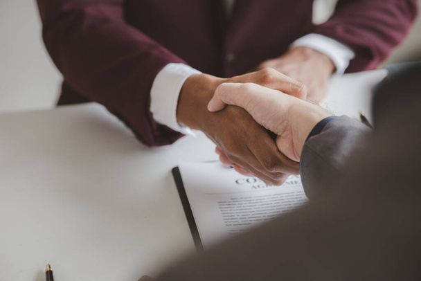 Lawyer and client shake hands, after winning a lawsuit where a lawyer hired by a client in a fraud case and proceeding in a fair and correct manner, the client wins the case. Fraud litigation concept. - Photo, Image
