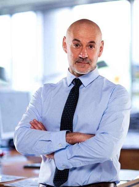 A man standing in the office and looking at camera. Businessman wearing shirt and tie. - Photo, Image
