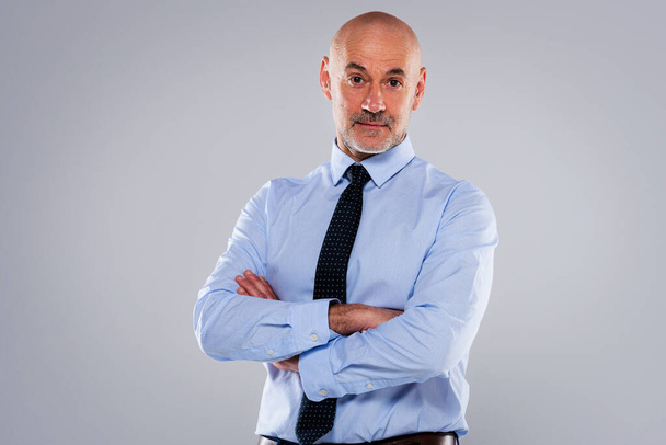 Shot of mid aged professional man wearing shirt and tie and standing at isolated background. Copy space. Folded arms. - Foto, immagini