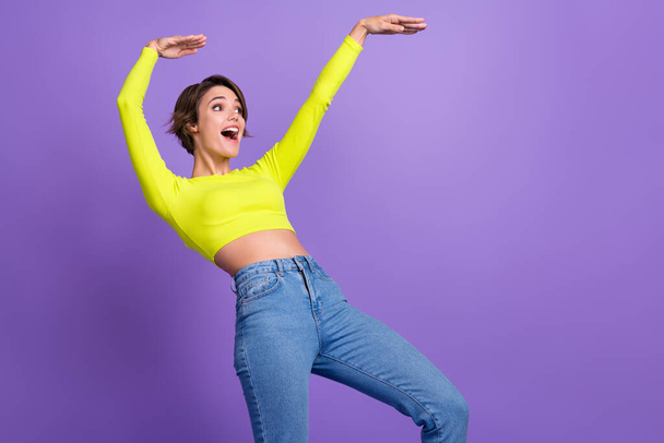 Photo of funky young girl fun dance listen music carefree good mood boogie woogie hands up look novelty isolated on purple color background. - Photo, Image
