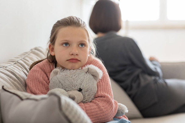 Unhappy cute teen daughter with toy ignores millennial caucasian woman in living room interior, close up. Quarrel, family, relationship problems, stress and parenting at home - Fotoğraf, Görsel