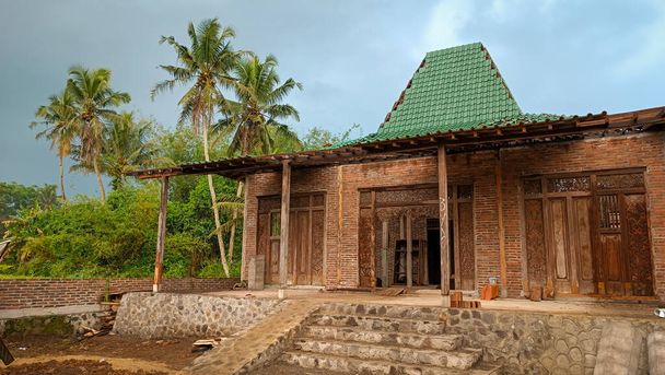 Javanese tradycyjny dom o nazwie joglo z drzewa kokosowego w tle  - Zdjęcie, obraz