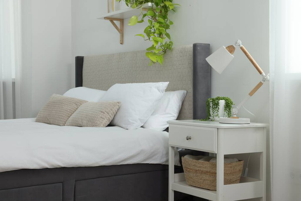 Stylish bedroom interior with large comfortable bed and bedside table - Fotó, kép