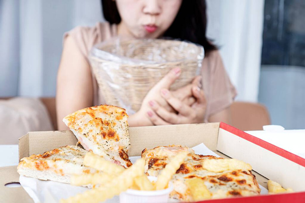Aasialainen nainen Oksentelu ja ruoansulatushäiriöt Koska ylensyönti Pizza, bulimia, humalahakuinen syöminen käsite - Valokuva, kuva