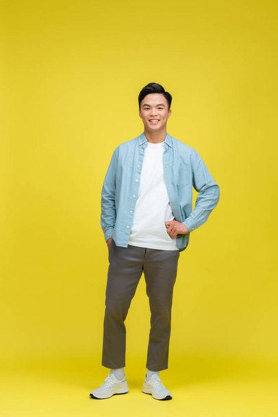 full body image of asian man posing on yellow background - Fotografie, Obrázek