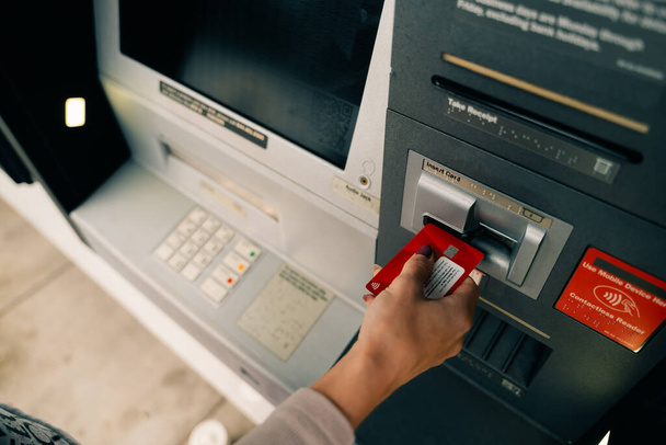 Meisje met een bankkaart bij een pinautomaat. Hoge kwaliteit foto - Foto, afbeelding