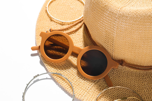 Joyería con gafas de sol y sombrero de verano sobre fondo blanco, primer plano - Foto, imagen
