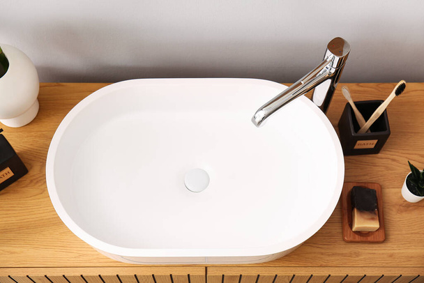 Lavabo bianco con accessori da bagno sul tavolo in camera, vista dall'alto - Foto, immagini