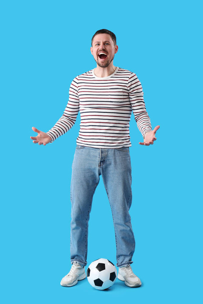 Screaming man with soccer ball on blue background - Photo, Image