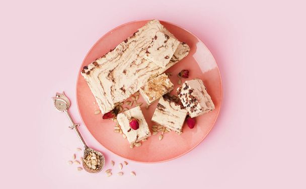 Plate with pieces of tasty marble halva on pink background - Photo, Image
