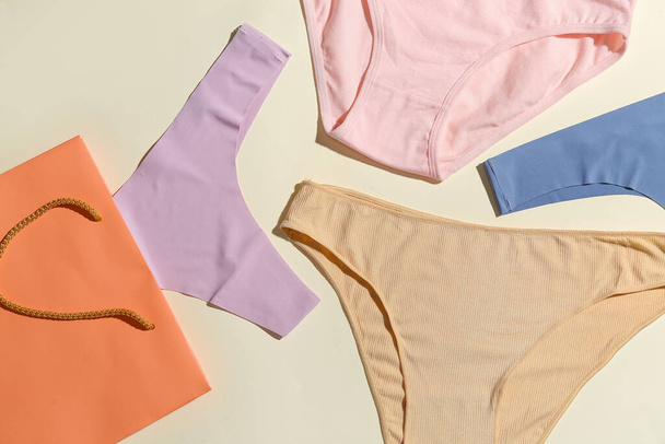 Set of stylish female panties and paper bag on light background, closeup - Photo, Image