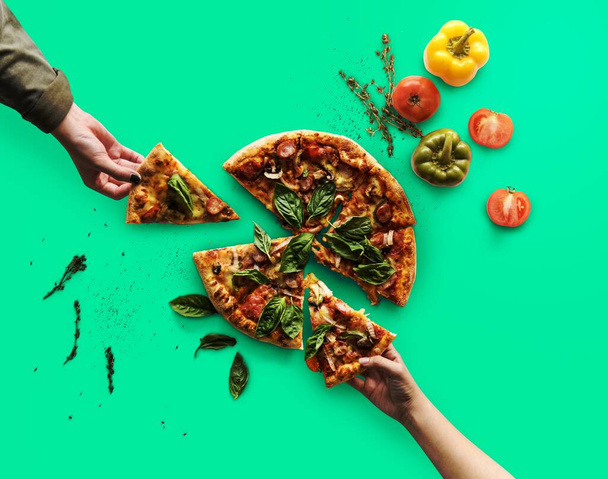 Handen nemen van plakjes Italiaanse keuken pizza - Foto, afbeelding
