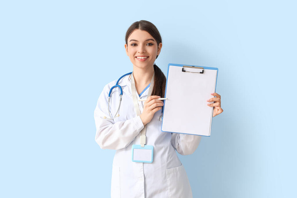 Female doctor on blue background - Foto, imagen