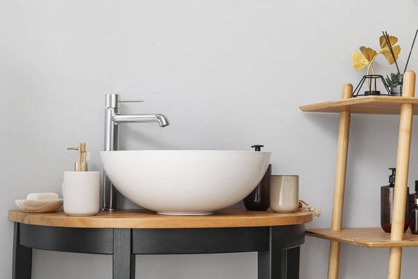 Spülbecken und Badezubehör auf dem Tisch im Badezimmer, Nahaufnahme - Foto, Bild