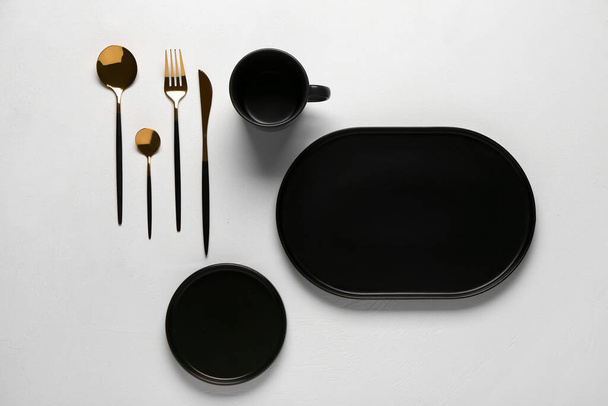 Saubere Teller, Tasse und goldenes Besteck auf grauem Tisch - Foto, Bild