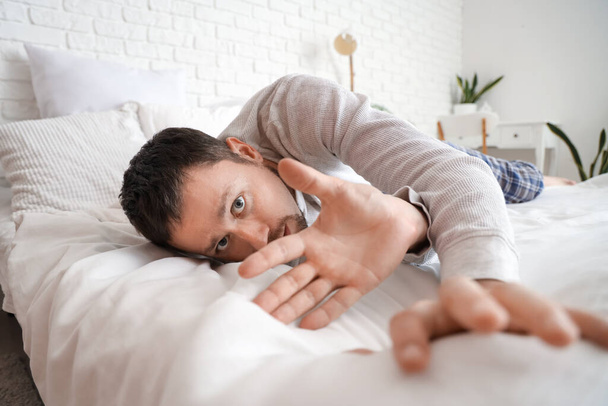 Giovane che ha un attacco di panico in camera da letto - Foto, immagini