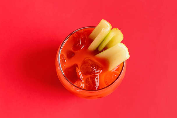 Glass of bloody mary with celery on red background - Photo, Image