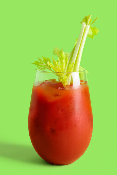 Glass of bloody mary with celery on green background - Photo, Image