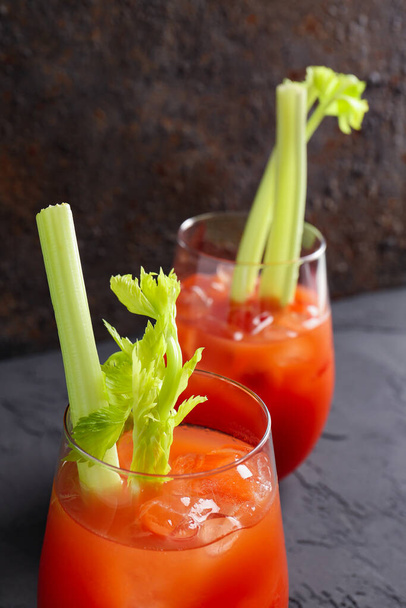 Glasses of bloody mary with celery on grey table - Φωτογραφία, εικόνα