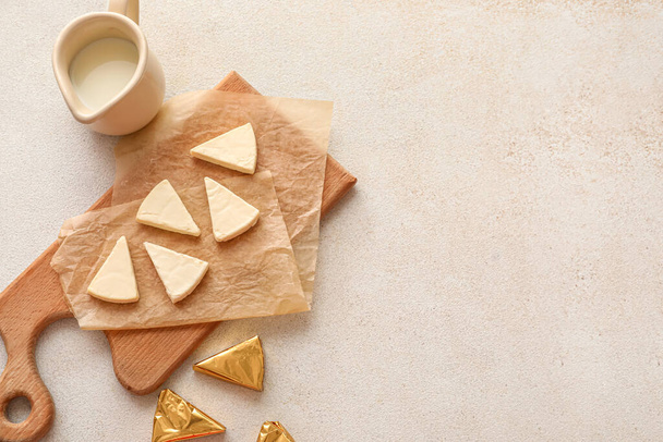 Placa com triângulos de queijo processado saboroso e leite no fundo leve - Foto, Imagem