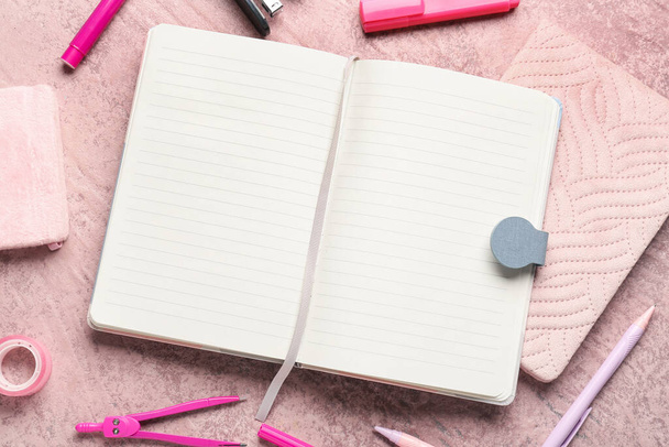 Notizbücher mit unterschiedlichem Papeterie auf Grunge-rosa Hintergrund - Foto, Bild