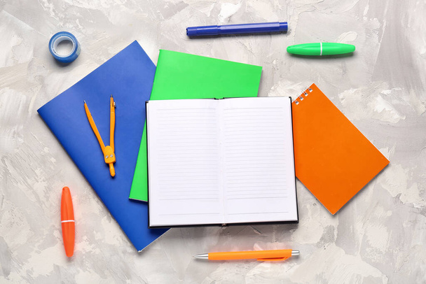 Notizbücher mit unterschiedlicher Schreibwaren auf weißem Grunge-Hintergrund - Foto, Bild