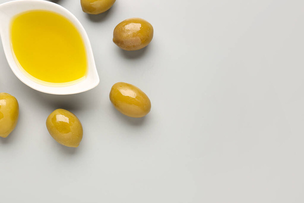 Bowl with fresh olive oil on grey background - Foto, immagini