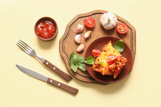 Plaat van pasta met tomatensaus en kaas op beige ondergrond - Foto, afbeelding