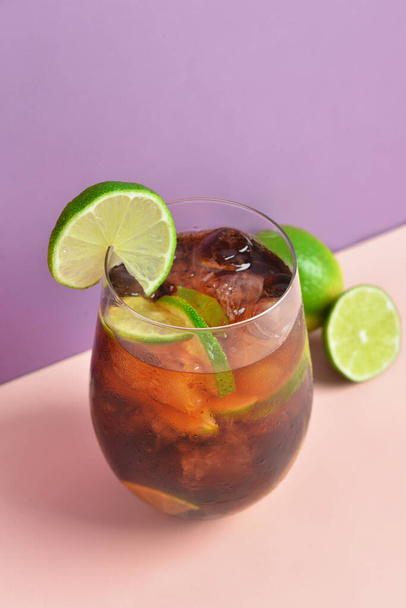 Glass of cold Cuba Libre cocktail on color background - Photo, Image