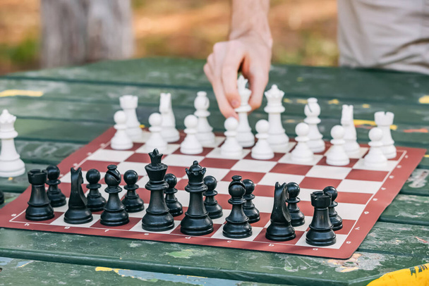 Sakkozni egy hajlékony mobil táblán egy asztalnál a parkban. Az elme, a stratégia és a készség fogalma - Fotó, kép