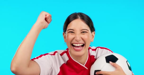 Face, soccer or woman with celebration, champion or female person against a blue studio background. Portrait, athlete or football player with winner, success or goal with fist, achievement or winning. - Footage, Video
