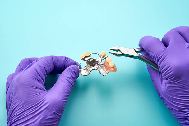 Стоматолог, який робить зубний протез, на зеленій верстаті. - Фото, зображення