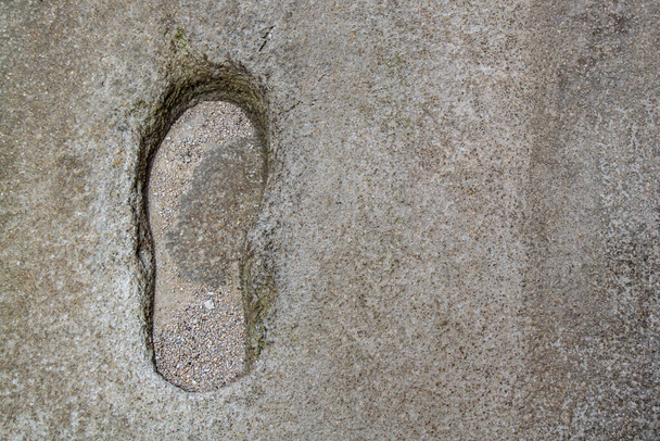 Deep left shoe print on the concrete floor of a street. - Foto, Bild