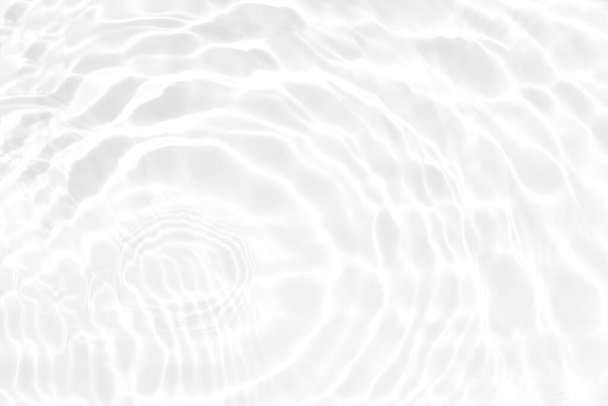 Valkoinen vesi, jonka pinnalla on aaltoja. Keskity hämärtynyt läpinäkyvä valkoinen värillinen kirkas rauhallinen veden pintarakenne roiskeita ja kuplia. Vesi aallot paistaa kuvio tausta. - Valokuva, kuva