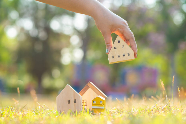 Drewniany model domu na zielonej trawie natire światła rezydentem nieruchomości koncepcji biznesu - Zdjęcie, obraz