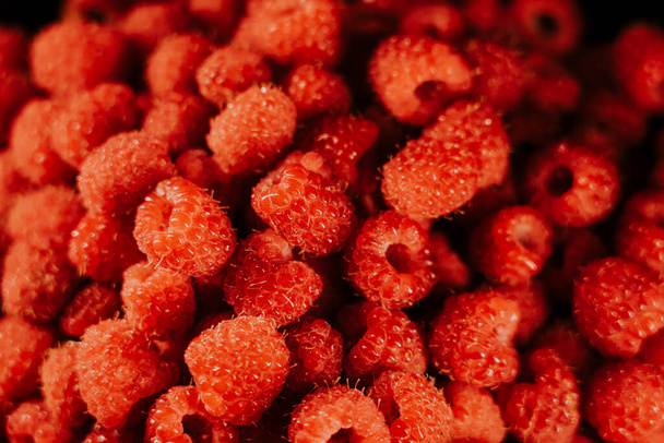 Fresh, ripe, juicy raspberry background, close up berry . Food background. Gastronomy concept, organic food. Macro red raspberries fruit in plate on black background - Photo, image