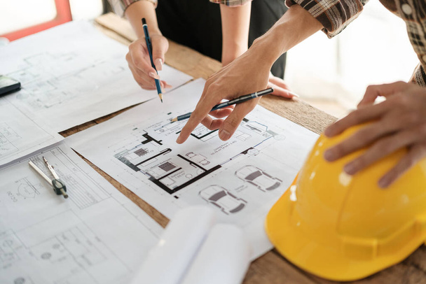 Architects talking at the table Teamwork and Workflow Creation Concepts, Close-up of Person Engineers Hand Drawn Plan on Blue Print with Architect Equipment. High quality photo - 写真・画像