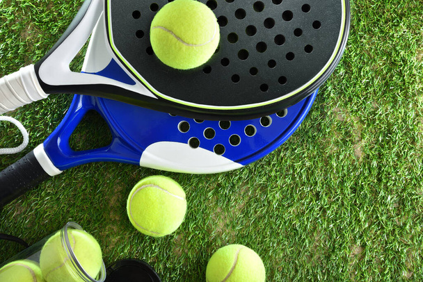 Two paddle tennis rackets and a can of balls on artificial grass. Top view. - Foto, Imagen