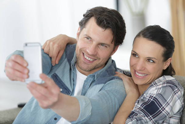 couple taking selfies with tablet computer at home - Foto, Imagem