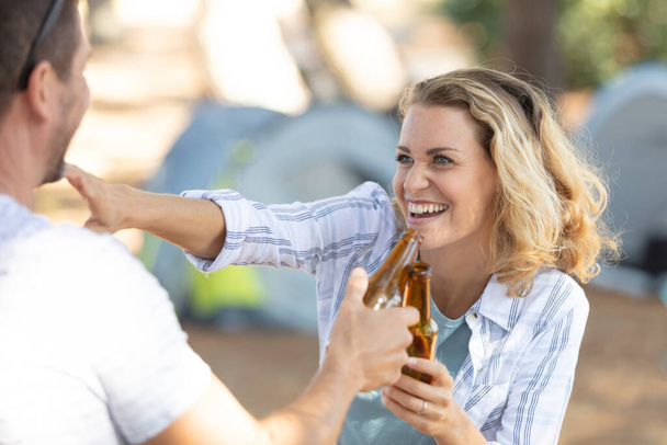 couple cheers with beers in the street - Photo, image