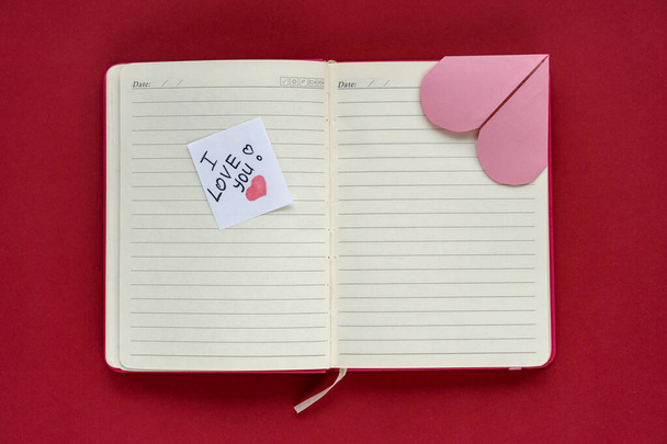 Bir kitap ve içinde "Seni seviyorum" yazan bir not, bir kitap aşığı için en iyi hediye. Sevgililer Günü, ilan-ı aşk. - Fotoğraf, Görsel