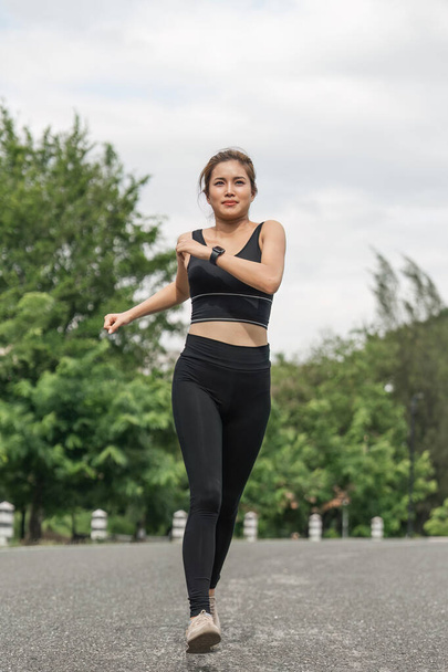 Young smiling sporty woman running in park in the morning. Fitness girl jogging in park. - Foto, Imagem