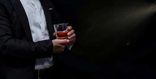 Closeup businessmen holding a glass of whiskey - Foto, afbeelding