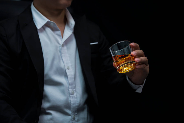 Closeup businessmen holding a glass of whiskey - 写真・画像