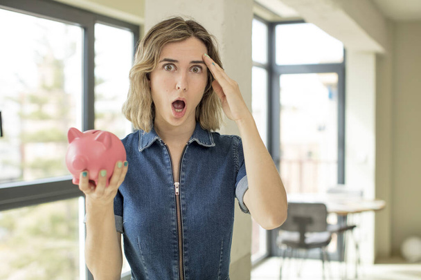 pretty woman looking happy, astonished and surprised. piggy bank concept - 写真・画像