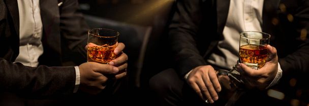 Closeup businessmen holding a glass of whiskey - Photo, image