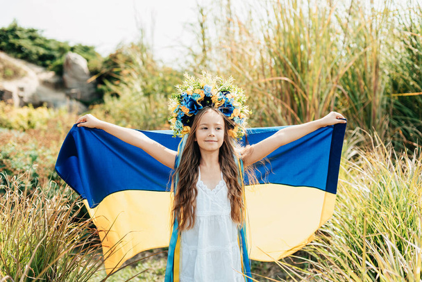 Ukrainian child girl with yellow and blue flag of Ukraine. Family, unity, support. Ukrainians are against war. Constitution day. Ukraines Independence Flag Day. - Фото, изображение