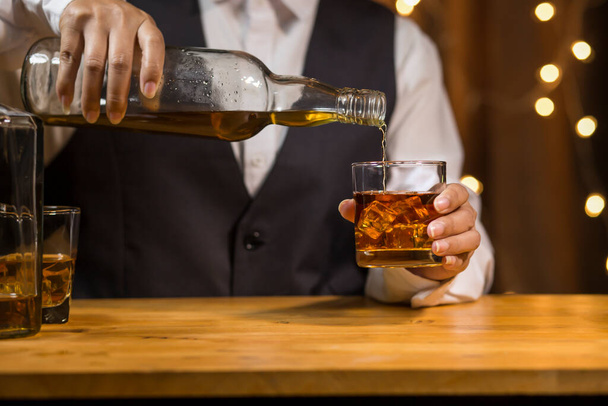 Barman Servir Whiskey, sur un bar en bois,  - Photo, image