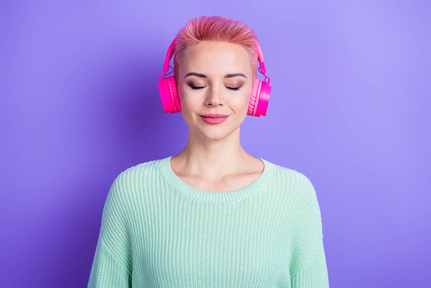 Photo of dreamy sweet lady dressed teal pullover listening songs earphones closed eyes isolated purple color background. - Foto, Bild